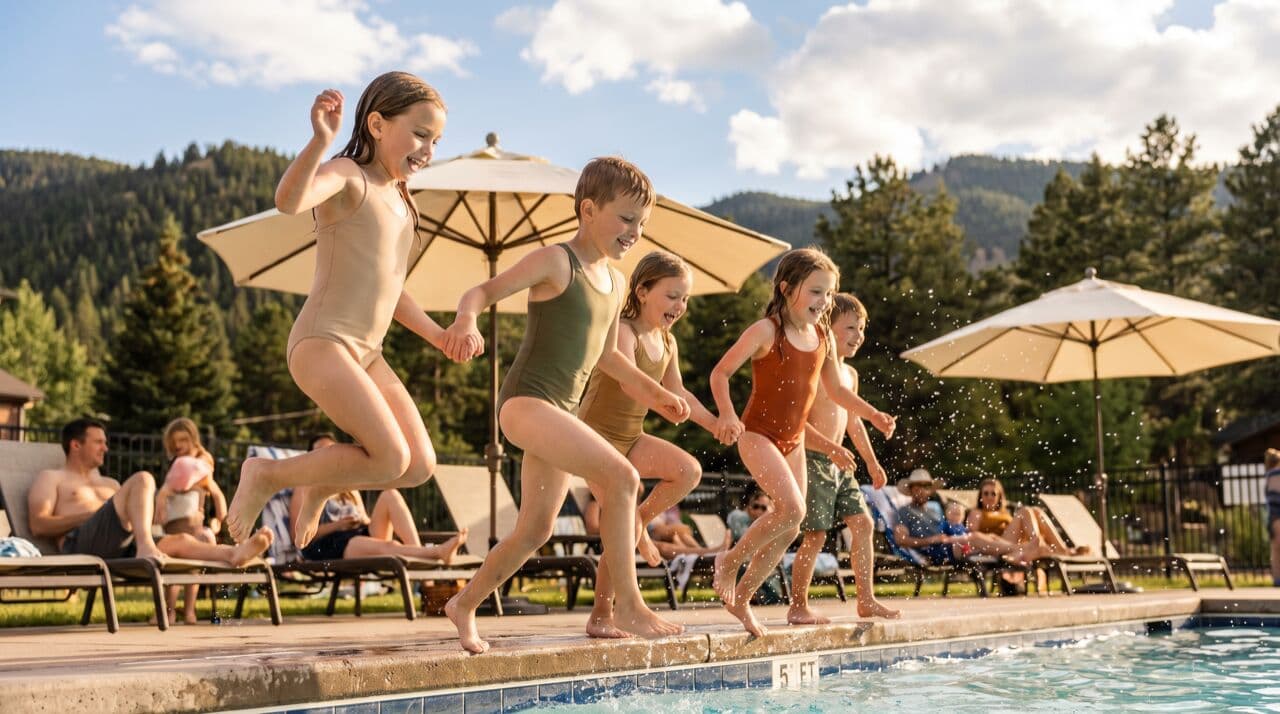 Children splashing in outdoor community pool on a bright Colorado summer day